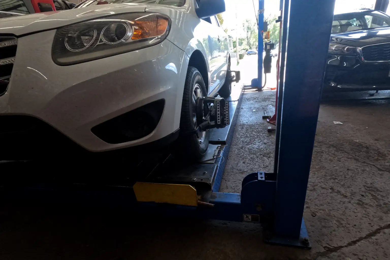 Technician working on wheel alignment machine